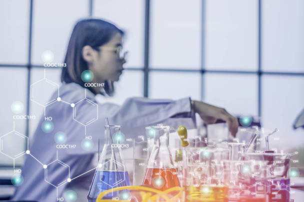 Sağlık renkli kimyasal şişeleri ve masanın üzerine yerleştirilen tüpler ile kimya laboratuarında çalışan kadın bilim adamı oturma Analizi ve iş ile meşgul. Kozmetik ve güzellik ürünleri hakkında. - Fotoğraf, Görsel