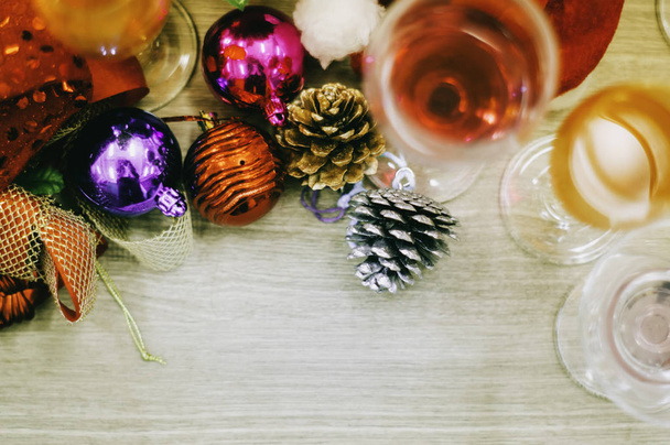 Vista superior de Navidad y mesa de madera con decoraciones, copa de vino, champán y cócteles, hermosas decoraciones ornamentales, espacio para copiar y texto
. - Foto, imagen
