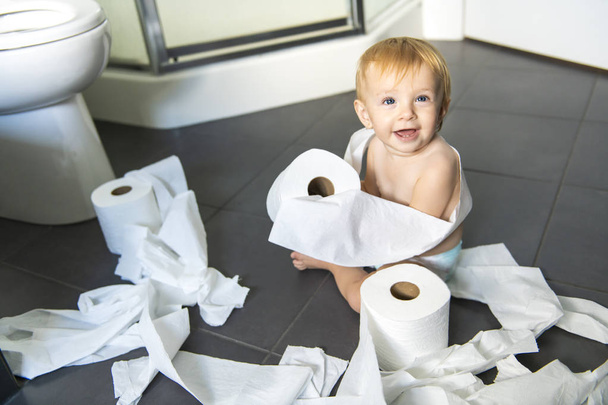 Toddler ripping up toilet paper in bathroom - Foto, Imagem