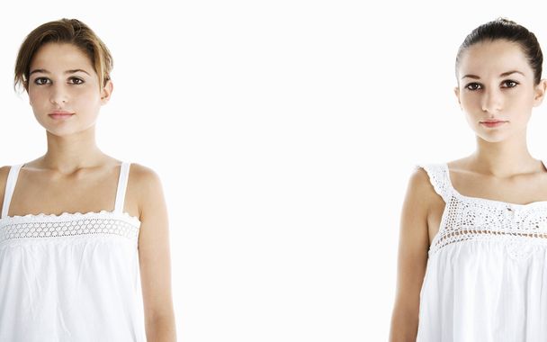 Deux jeunes femmes debout sur un fond blanc avec une distance entre elles
. - Photo, image
