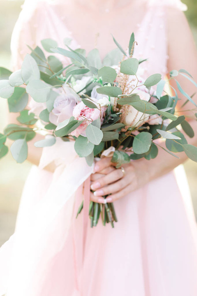 brides hands hold a beautiful bridal bouquet outdoor - Foto, Imagem