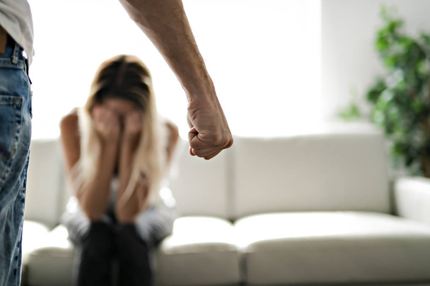 Man geslagen zijn vrouw ter illustratie van huiselijk geweld - Foto, afbeelding