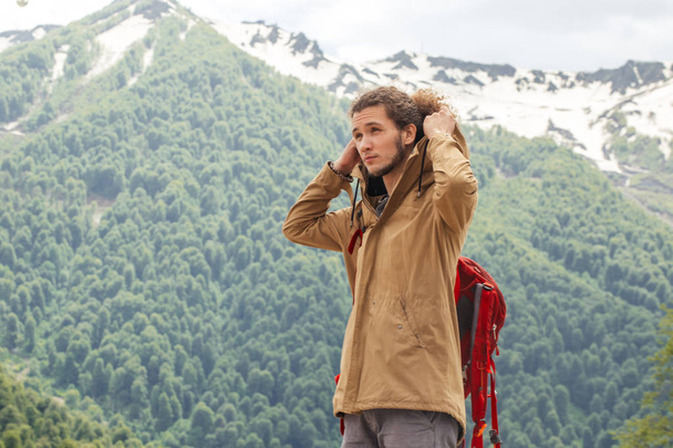 Man Traveler with red backpack relaxing outdoor with rocky mountains on background - Φωτογραφία, εικόνα