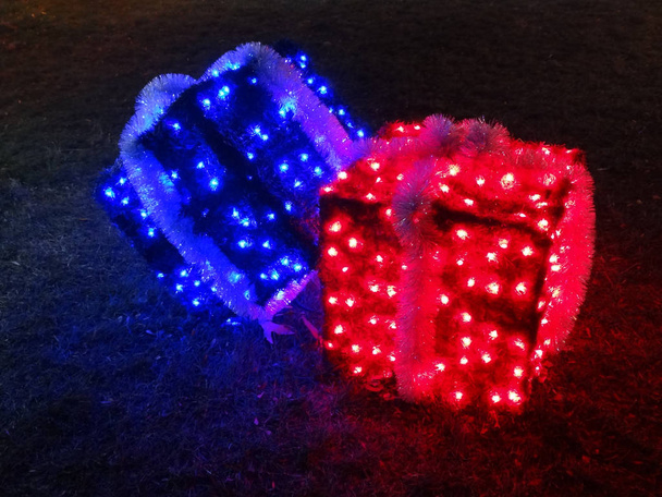 Φωτιζόμενα κουτιά δώρων Χριστουγέννων με κόκκινο και μπλε φώτα - Φωτογραφία, εικόνα