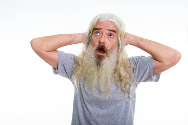 Студійний знімок старшого бородатого чоловіка, який думає, дивлячись шокованим
 - Фото, зображення