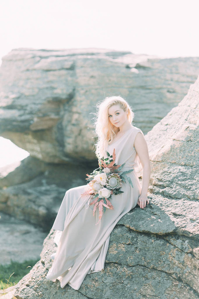 Bride in nature, in the mountains. Wedding in the style of fine art. The mountains and the sunset in the boudoir dress. - Foto, Imagem