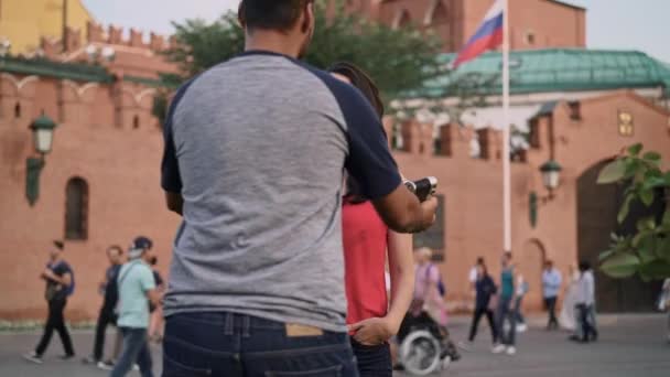 Tourist taking photo of his wife near Moscow Kremlin in summer - Felvétel, videó