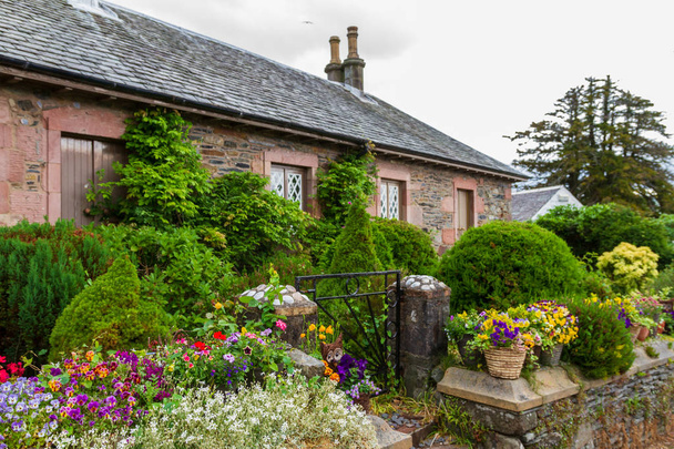 Υπέροχο παραδοσιακό σπίτι και τους κήπους με το χωριό του Luss στο Loch Lomond στη Σκωτία, Ηνωμένο Βασίλειο. - Φωτογραφία, εικόνα