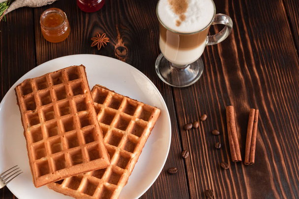 Tasty fresh Vienna wafers, jam and cup of coffee on a dark wooden background - Photo, Image