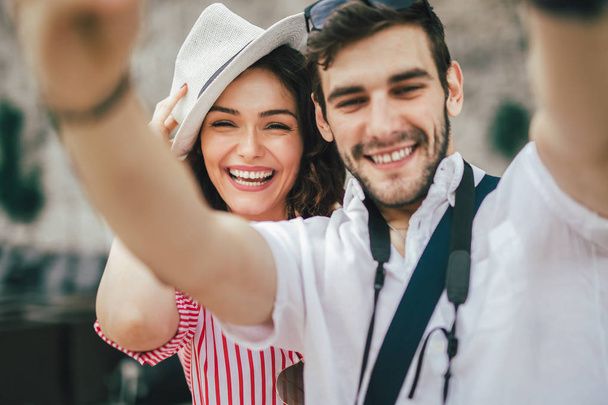 Heureux jeune couple faire selfie ensemble et souriant
. - Photo, image
