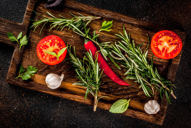Cooking background, herbs and vegetables on cutting board, dark rusty background copy space top view - Φωτογραφία, εικόνα