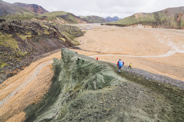 Turistas trekking en las coloridas montañas del Parque Nacional Landmannalaugar, Islandia
. - Foto, Imagen