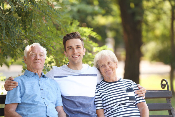 Man with elderly parents on bench in park - Foto, Imagem