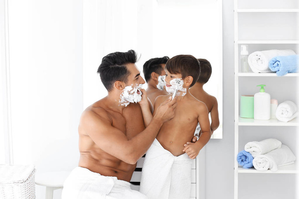 Father and son having fun while shaving in bathroom - Foto, afbeelding