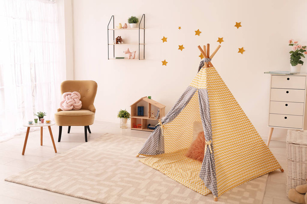 Cozy child's room interior with play tent and toys - Фото, зображення
