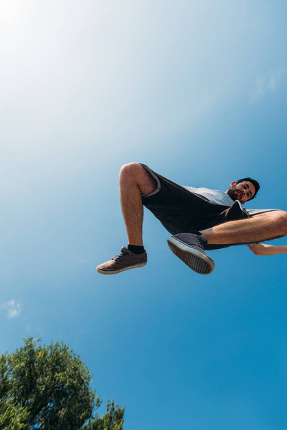 Parkour man exercising parkour jumping below sky - Fotoğraf, Görsel