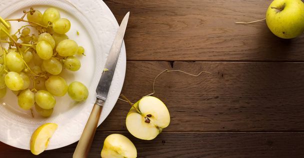 Alimenti sani; uva fresca e succosa biologica e mela su un tavolo
 - Foto, immagini