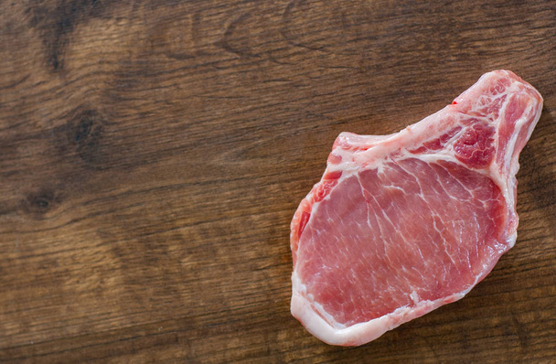 Raw Pork Loin chops meat on wooden table background with copy space. top view - Foto, Imagem