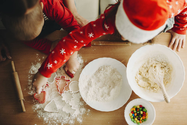 From above shot of children with cutters making cookies for Xmas holiday at table - Foto, imagen