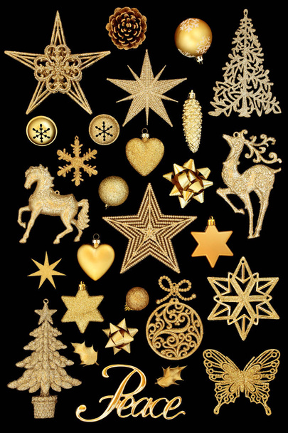 Signo de paz de oro navideño que incluye adornos de adornos de bolas de árbol aislados sobre fondo negro
. - Foto, imagen
