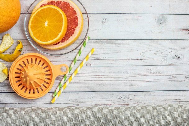 フレッシュ ライトの木製テーブルの柑橘フルーツとオレンジの手動ジューサーをスライスします。平面図です。コピー スペース. - 写真・画像