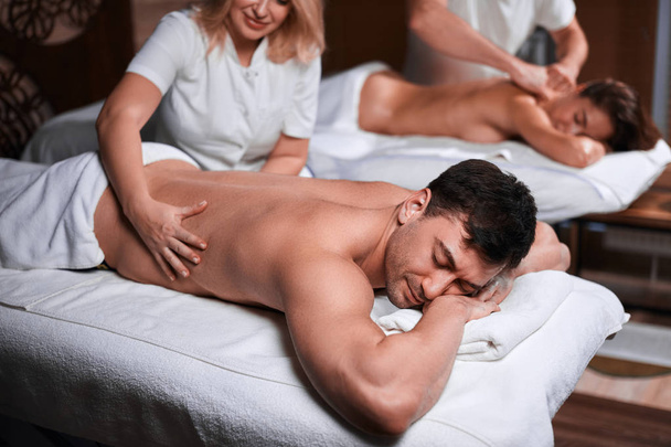Man receiving back massage from masseur in spa - Fotó, kép