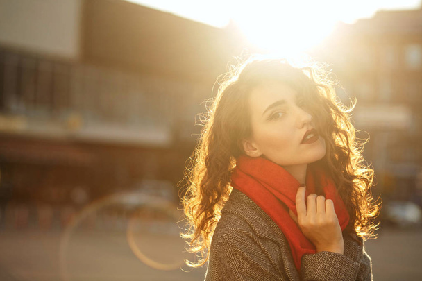 Portret styl życia piękny model brunetka z kręconymi włosami sobie jesienny płaszcz oversize i czerwonym szalikiem. Puste miejsce - Zdjęcie, obraz