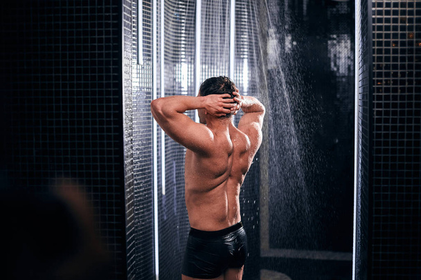 Komea mies suihkussa, virkistävä itsensä jälkeen kuuma työpäivä. - Valokuva, kuva