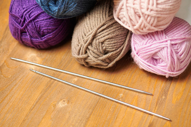fili di lana colorati per maglieria su sfondo di legno
 - Foto, immagini
