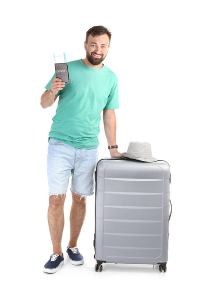 Man with suitcase and passport on white background. Vacation travel - Foto, Imagen