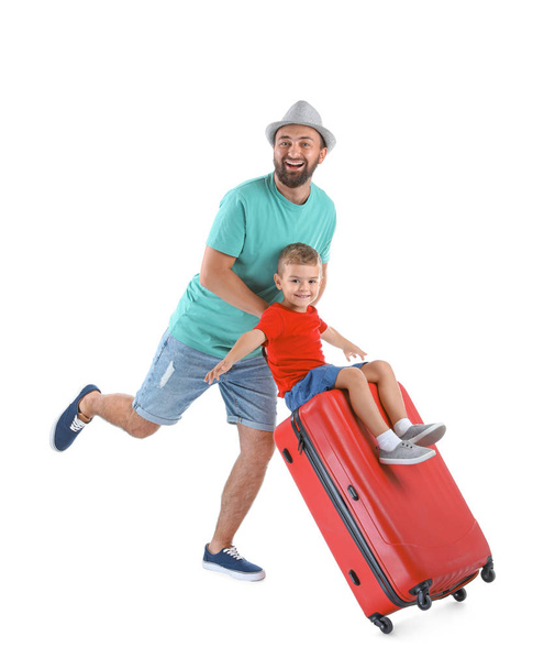 Man and his son playing with suitcase on white background. Vacation travel - Fotó, kép