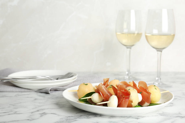 Melon, mozzarella and prosciutto skewers served on marble table. Space for text - Photo, Image