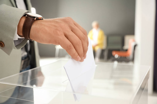 Frau legt Stimmzettel in Wahllokal in Urne - Foto, Bild
