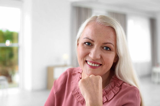 Portrait of beautiful older woman against blurred background - Фото, зображення