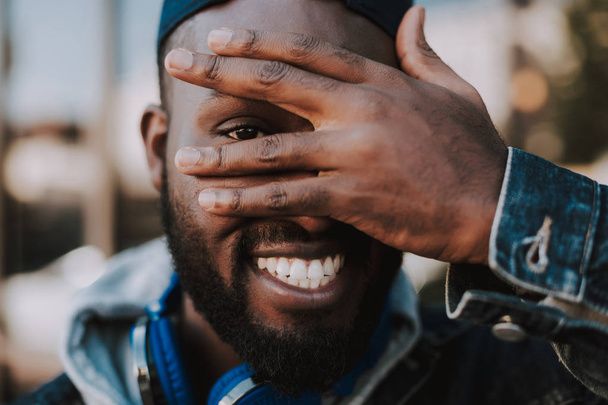 Joyful afro american man holding his hand on the face - Zdjęcie, obraz
