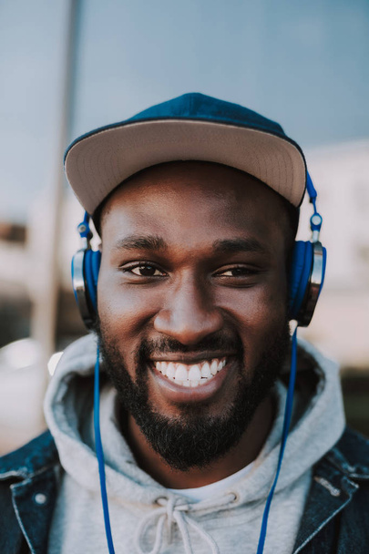 Portrait of a cheerful young man listening to music - Фото, изображение