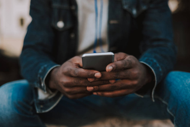 Close up of a smartphone in hands of amro american man - Φωτογραφία, εικόνα