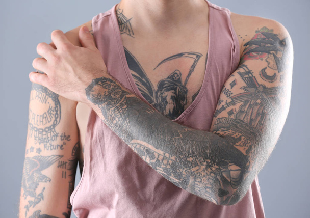 Young man with stylish tattoos on white background - Fotografie, Obrázek