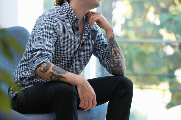 Young man with stylish tattoos on white background - Фото, зображення