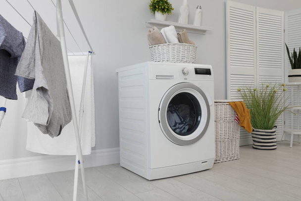 Laundry room interior with washing machine near wall - Фото, изображение