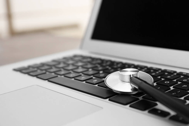 Modern laptop and stethoscope, closeup. Technical support concept - Photo, Image