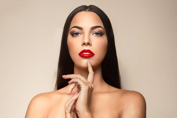 Portrait of beautiful young woman with red glossy lips on color background - Φωτογραφία, εικόνα