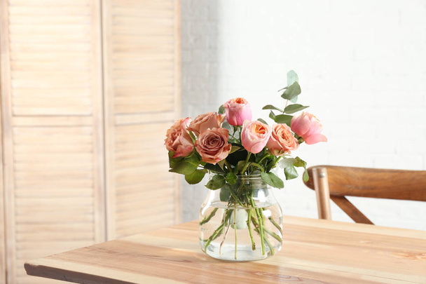 Ваза з красивими квітами як елемент дизайну інтер'єру на столі в кімнаті
 - Фото, зображення