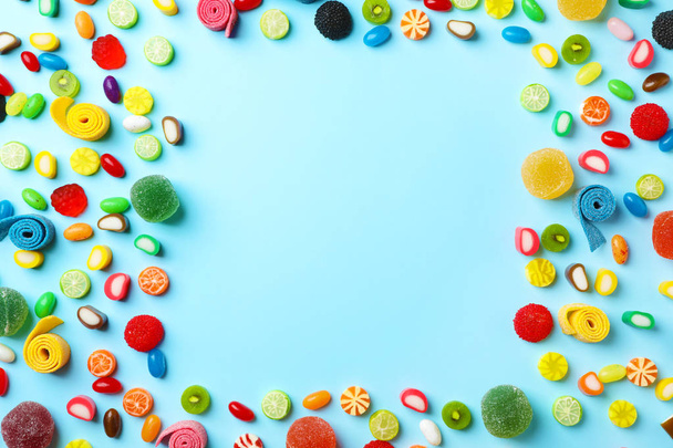 Flat lay composition with delicious colorful candies and space for text on color background - Foto, immagini