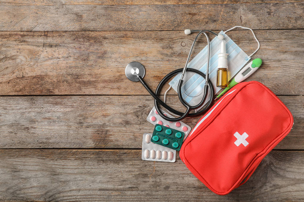 Flat lay composition with first aid kit and space for text on wooden background - Photo, image