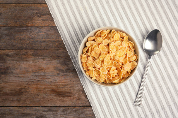 Bowl with healthy cornflakes for breakfast on wooden table, top view. Space for text - Foto, imagen