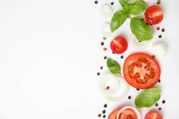 Hojas de albahaca verde fresca, tomates y mozzarella sobre fondo blanco, vista superior
 - Foto, imagen