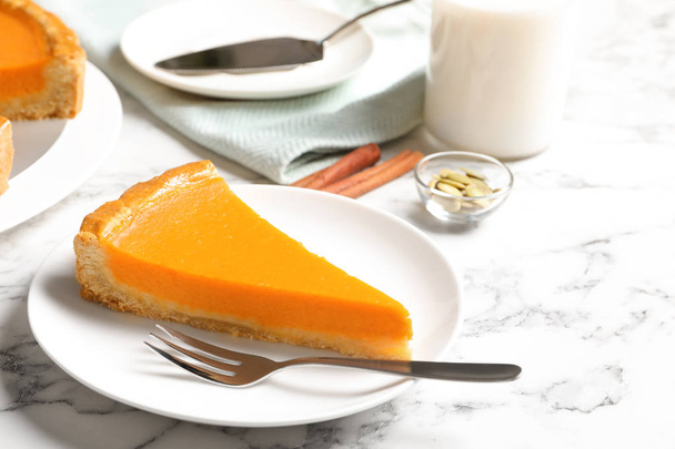 Plate with piece of fresh delicious homemade pumpkin pie on marble table - Fotó, kép