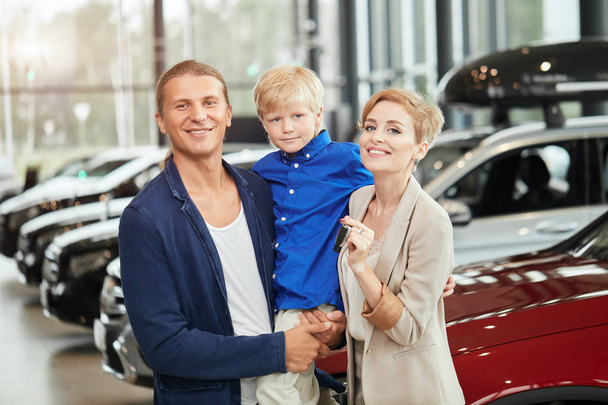 automobile sales centre. young family with child boy in car sell - Foto, Imagen
