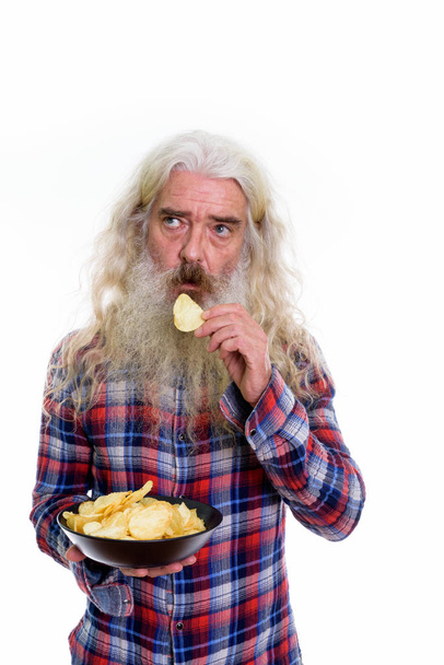 Kase yemek yerken düşünme üst düzey sakallı adam stüdyo çekim  - Fotoğraf, Görsel